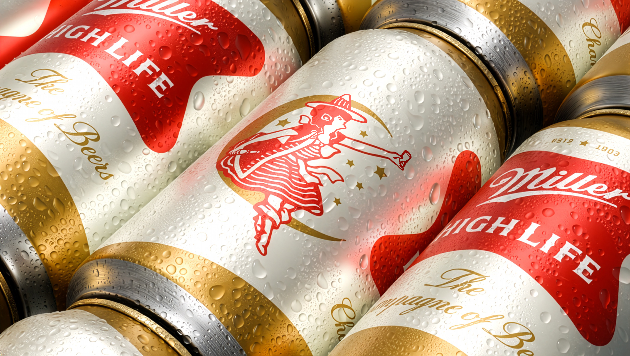 Close-up of various cans of Pabst Blue Ribbon beer with water droplets on the surface.