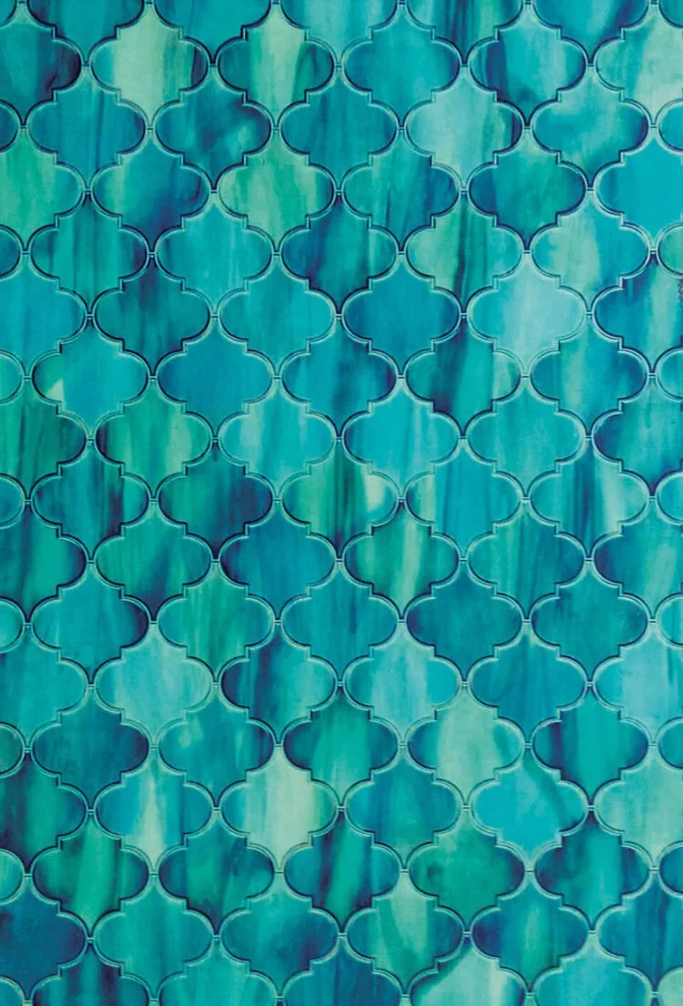 Close-up of a blue and green tiled surface with a quatrefoil pattern.