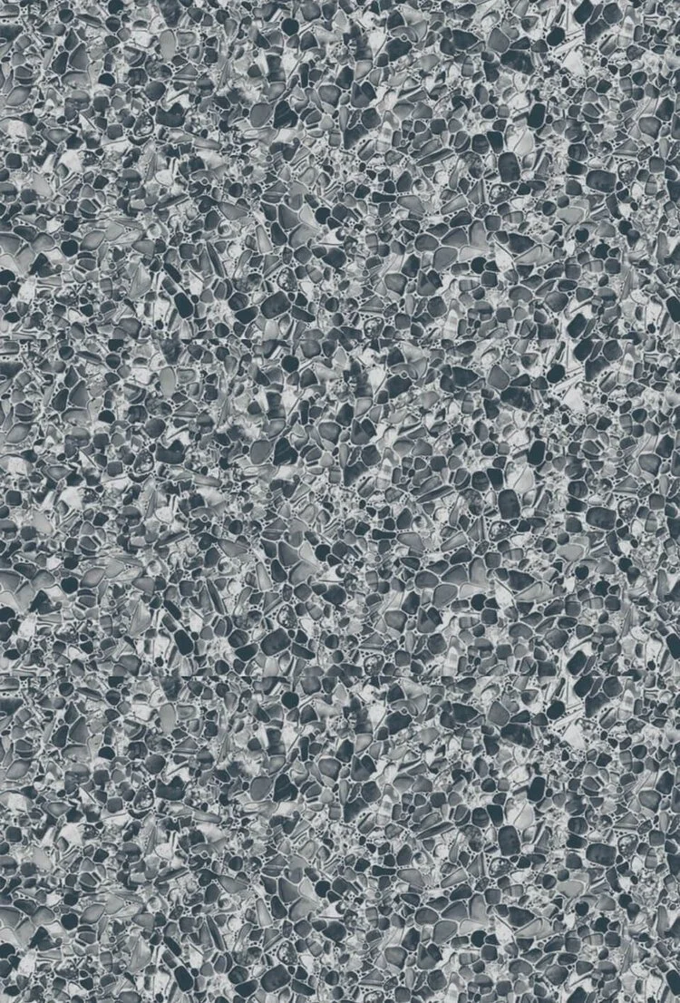 Close-up view of a speckled, mosaic tile surface with small, irregularly shaped gray and black stone pieces.