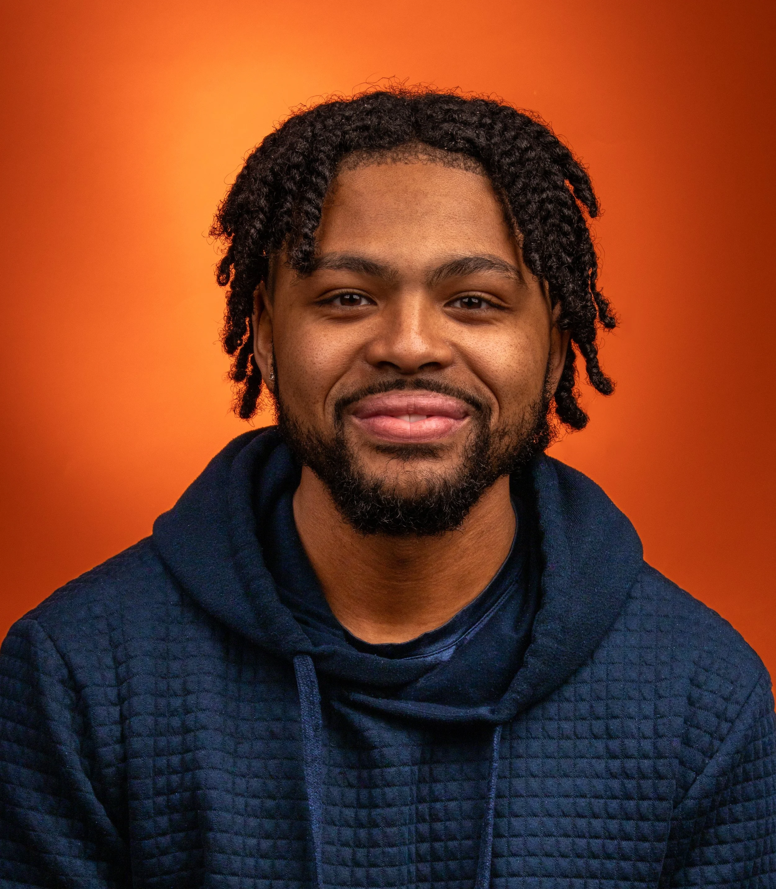 Headshot of a man on an oragen background