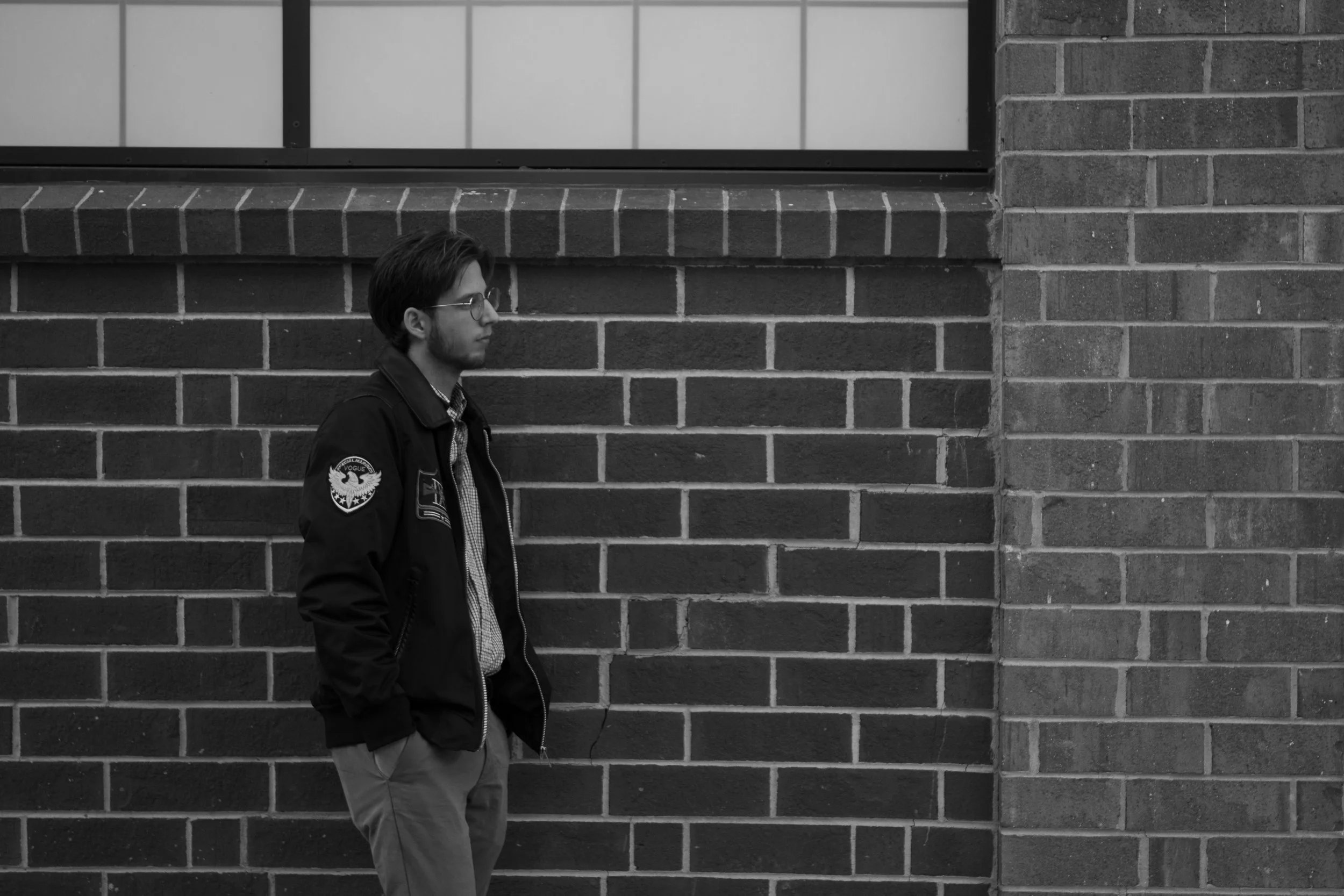 Man standing outside against brick wall