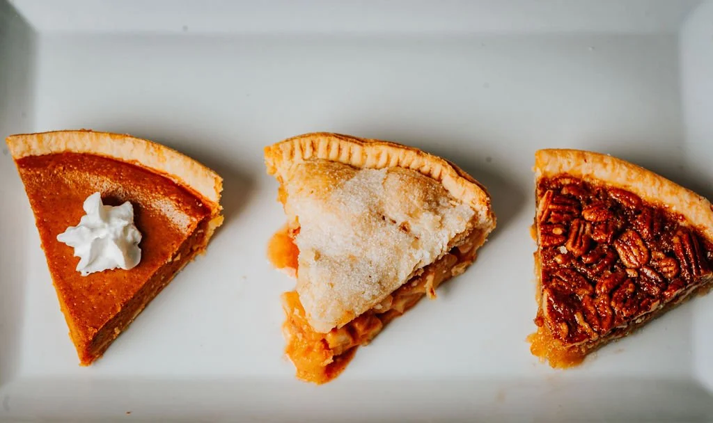 Three slices of different types of pie on a white plate.