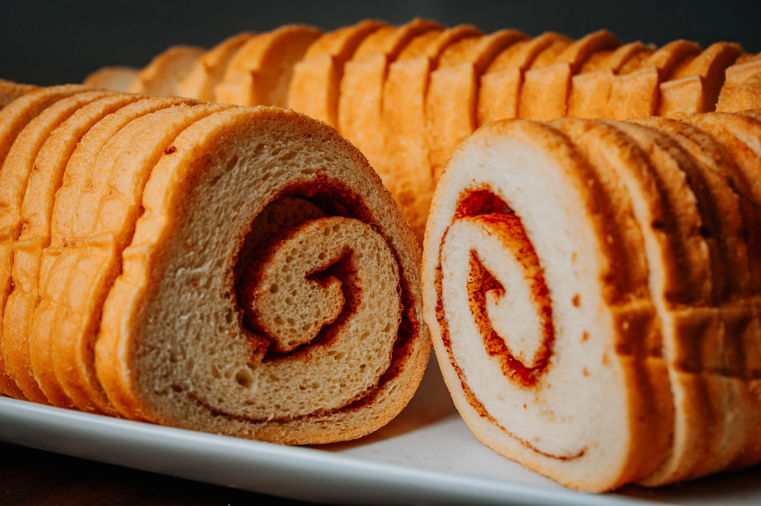 Close-up of two slices of cinnamon crimp bread arranged on a white plate.