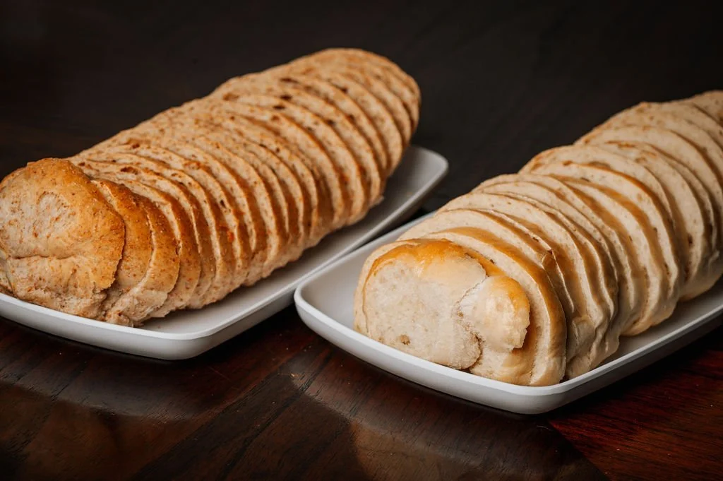 Two plates of sliced bread with a soft, fluffy interior. The bread is golden brown and appears to be freshly baked.