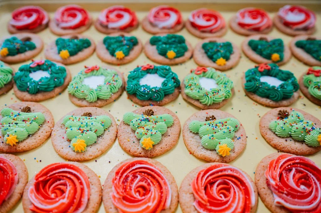 Assorted decorated sugar cookies with Christmas themes, including Christmas trees, wreaths, and swirls.
