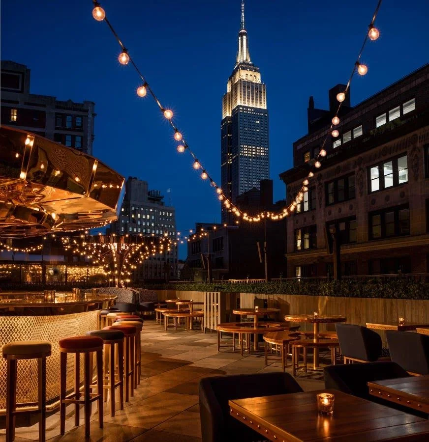 Elegant Manhattan rooftop at night with skyline view, representing a refined and memorable evening experience in New York City
