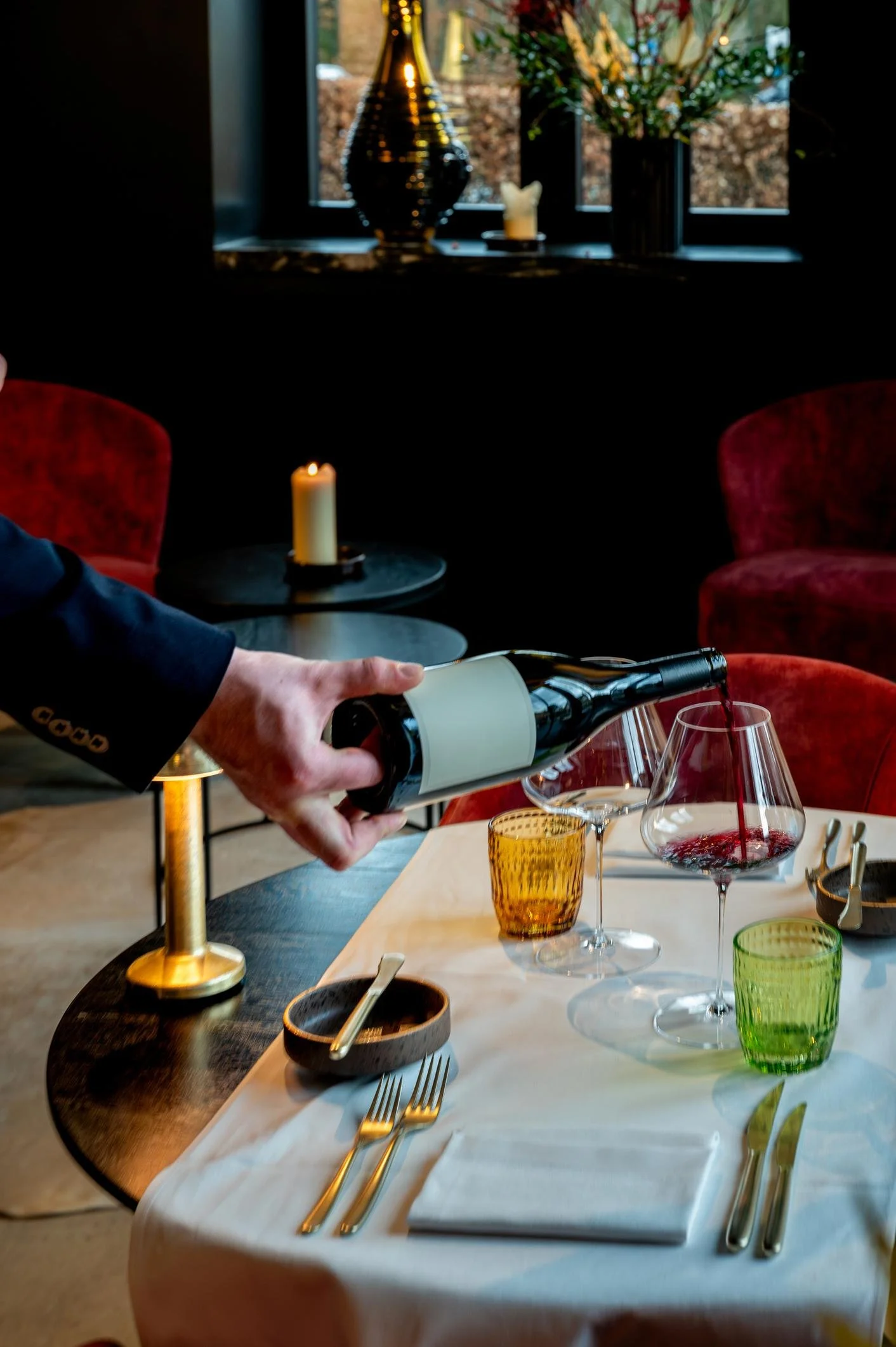 Server pouring red wine at private dining table