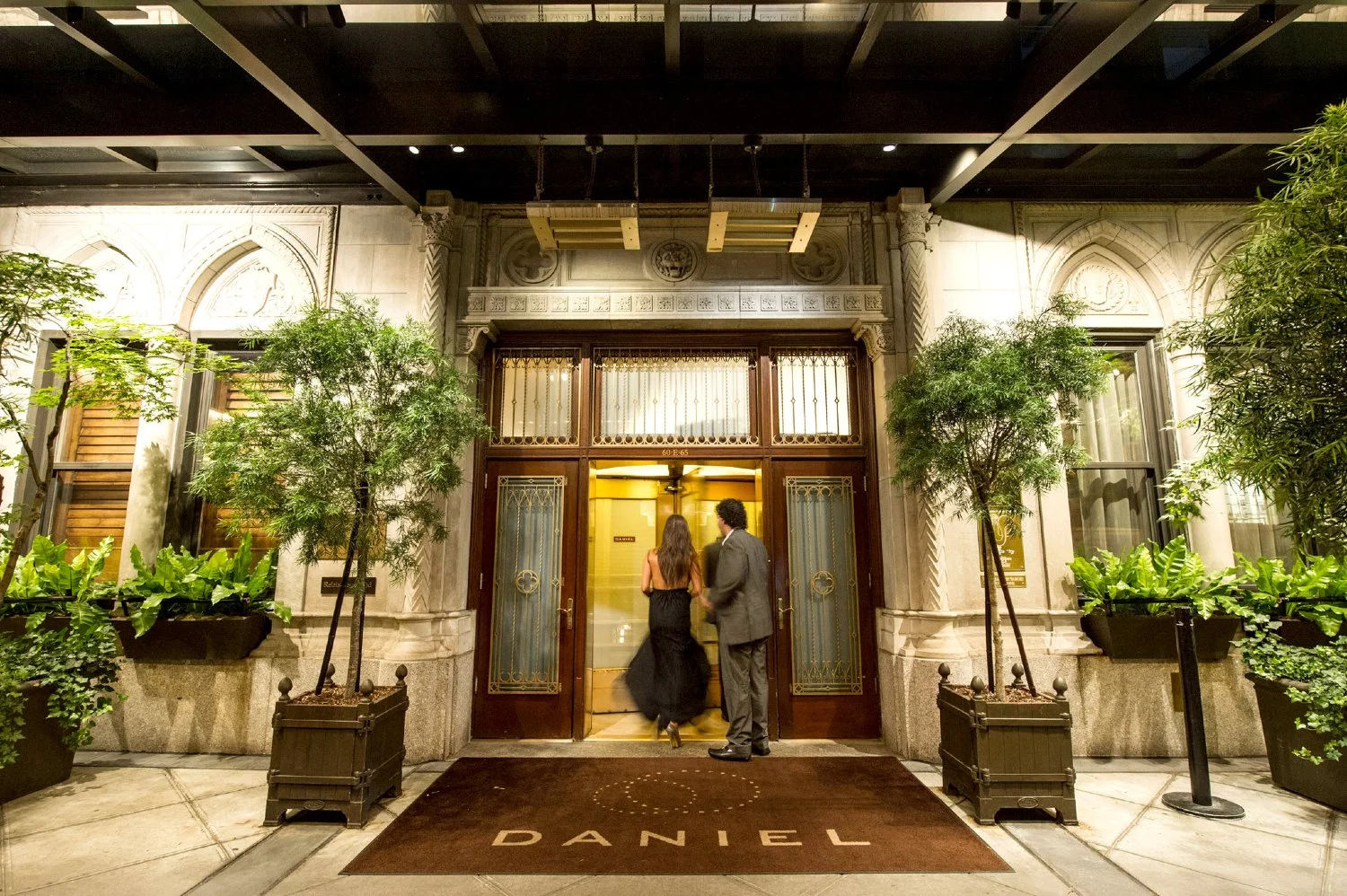Elegant couple entering a luxury restaurant in Manhattan, representing a refined and well-planned evening experience
