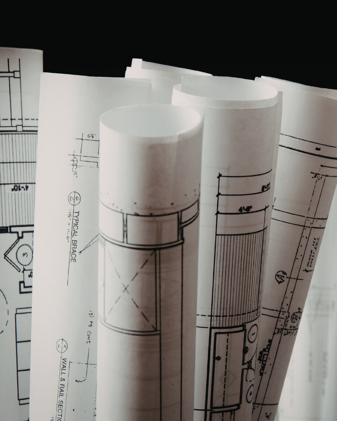 Rolled architectural blueprints with technical drawings and measurements.