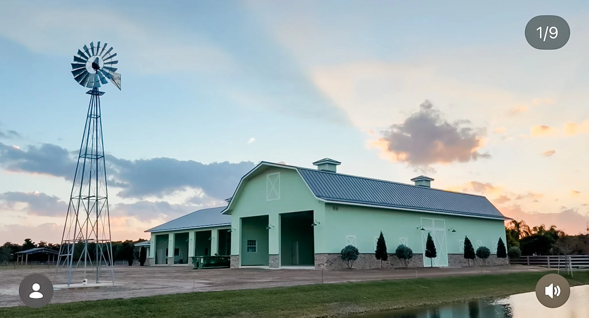 Discount Development Group completed shell construction project: large light green equestrian barn with white trim and metal roof, landscaped yard, in Wellington, Florida.