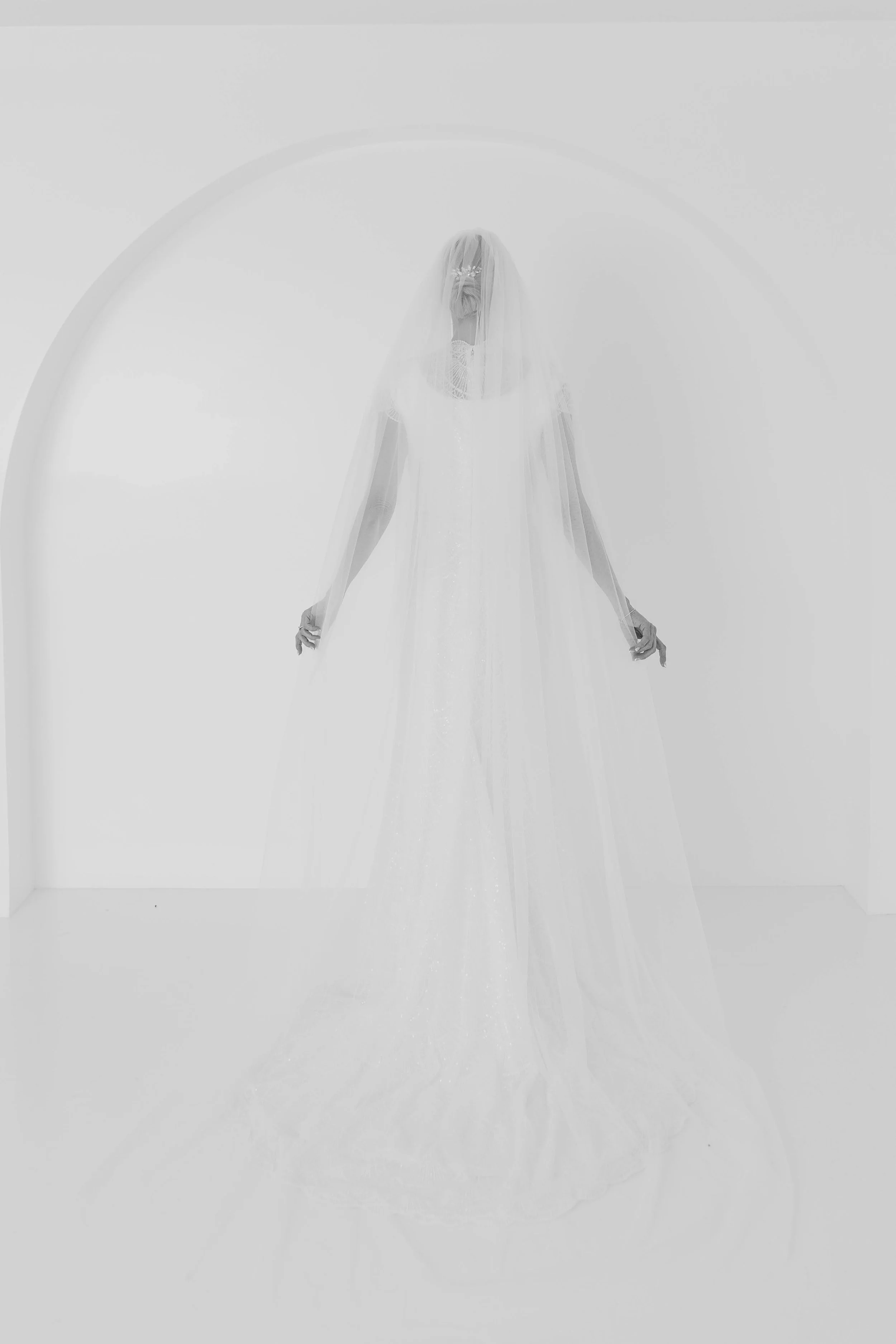 The image looks like a bride with a veil — so for that photo: IMAGE ALT TEXT: Bride holding veil during wedding photography session