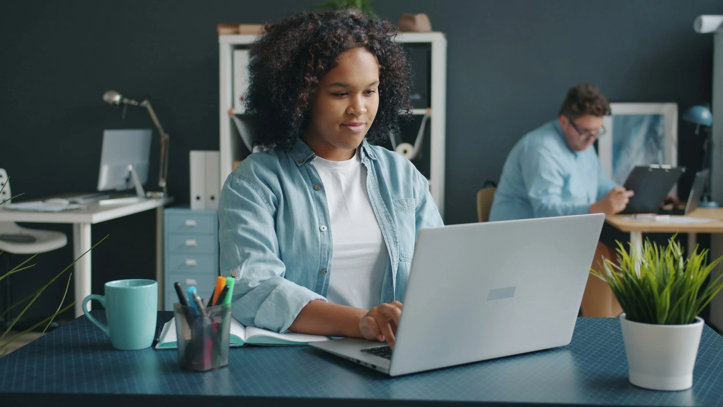 woman sitting at desk looking at laptop