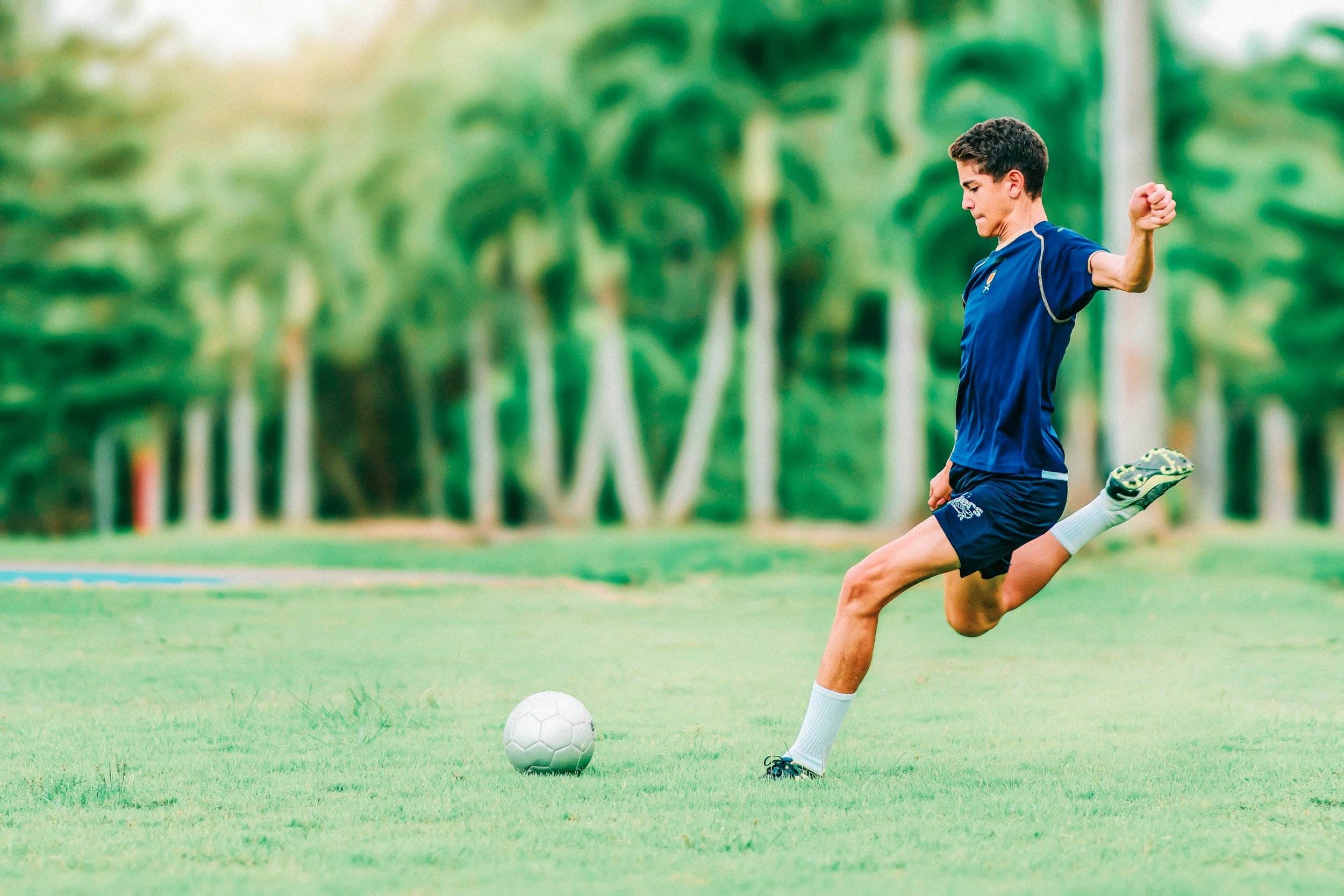 man kicking a soccer ball