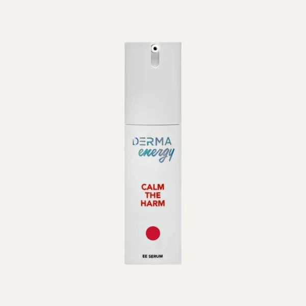 A white spray bottle labeled 'DERMA energy' with the slogan 'Calm the Harm' and a red dot, used as an EE serum.