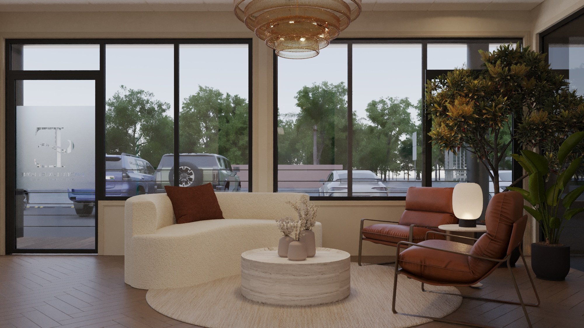 Living room with large front window overlooking parked cars and trees outside, furnished with beige sofa, brown armchair, small white table lamp, and decorative vases on a round coffee table, with a modern chandelier overhead.