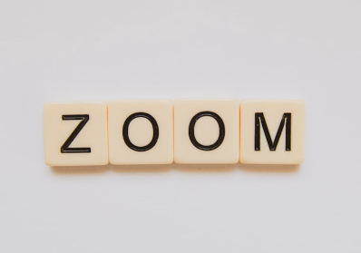 Four cream-colored tiles spelling out the word "ZOOM" with black letters on a white background.