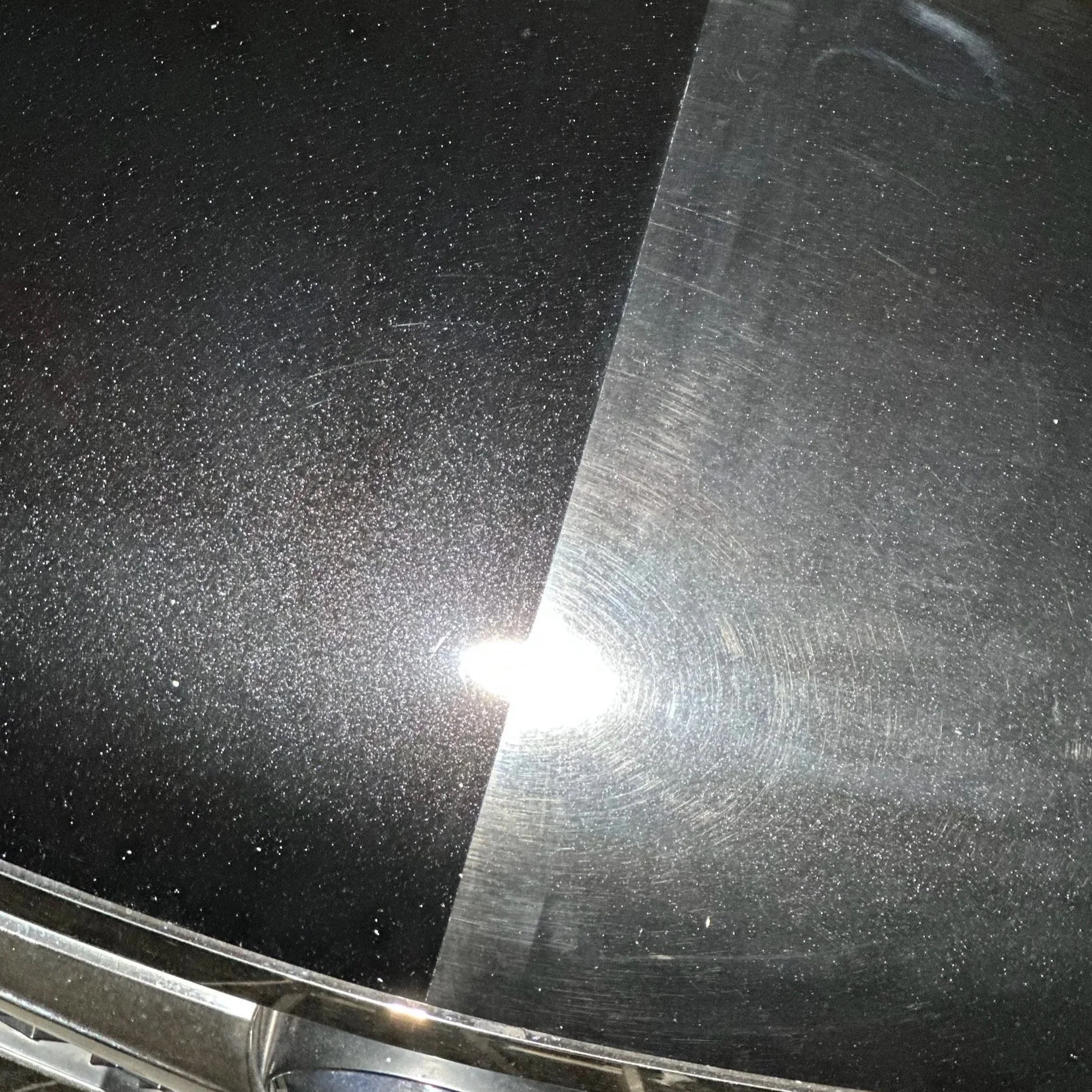Paint correction before and after showing swirl mark removal under inspection lighting on black paint.