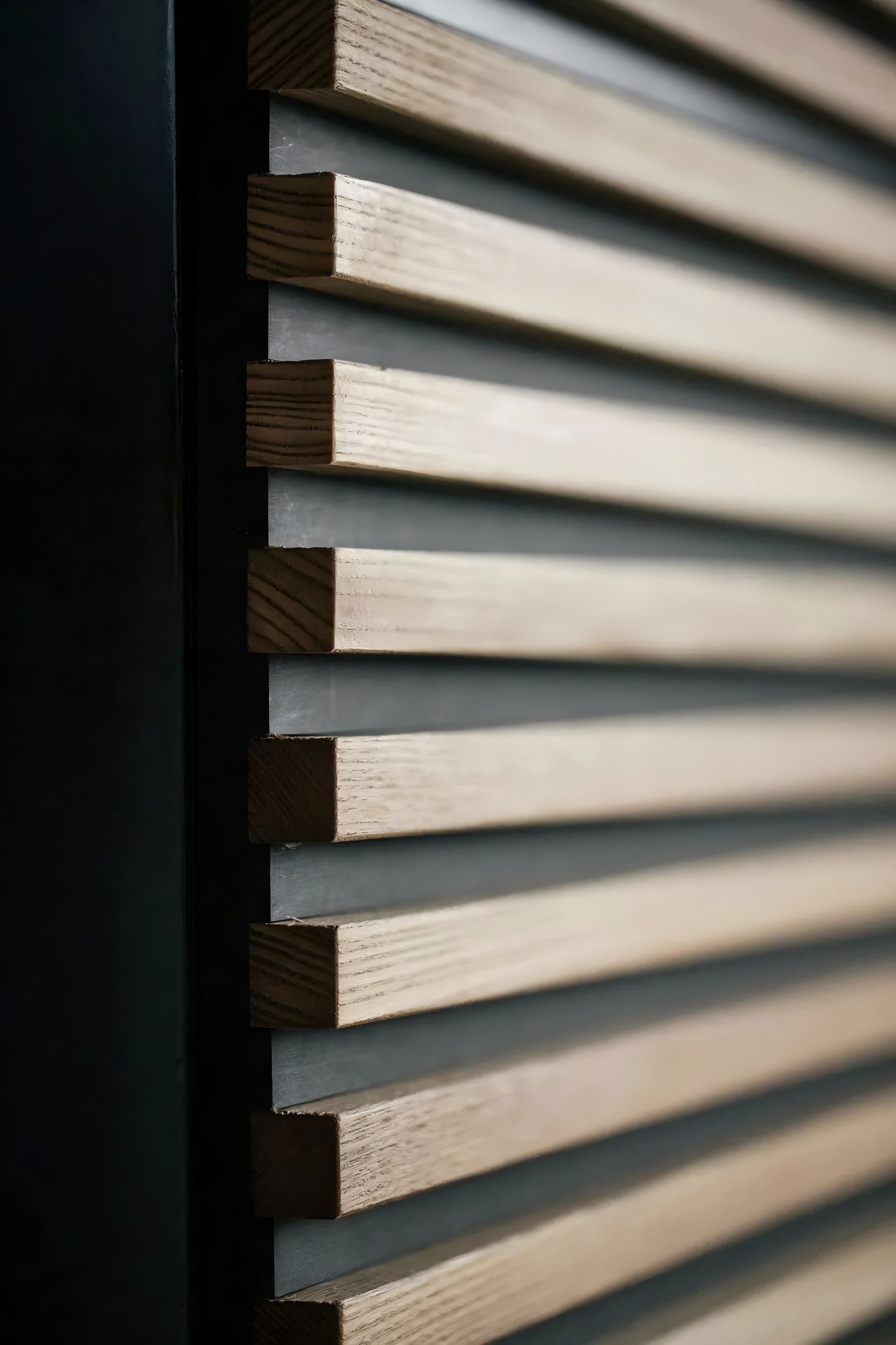 Close-up view of wooden slats arranged horizontally on a wall, with the left side partially obscured.