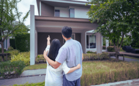 A couple looking at a house in a suburban neighborhood