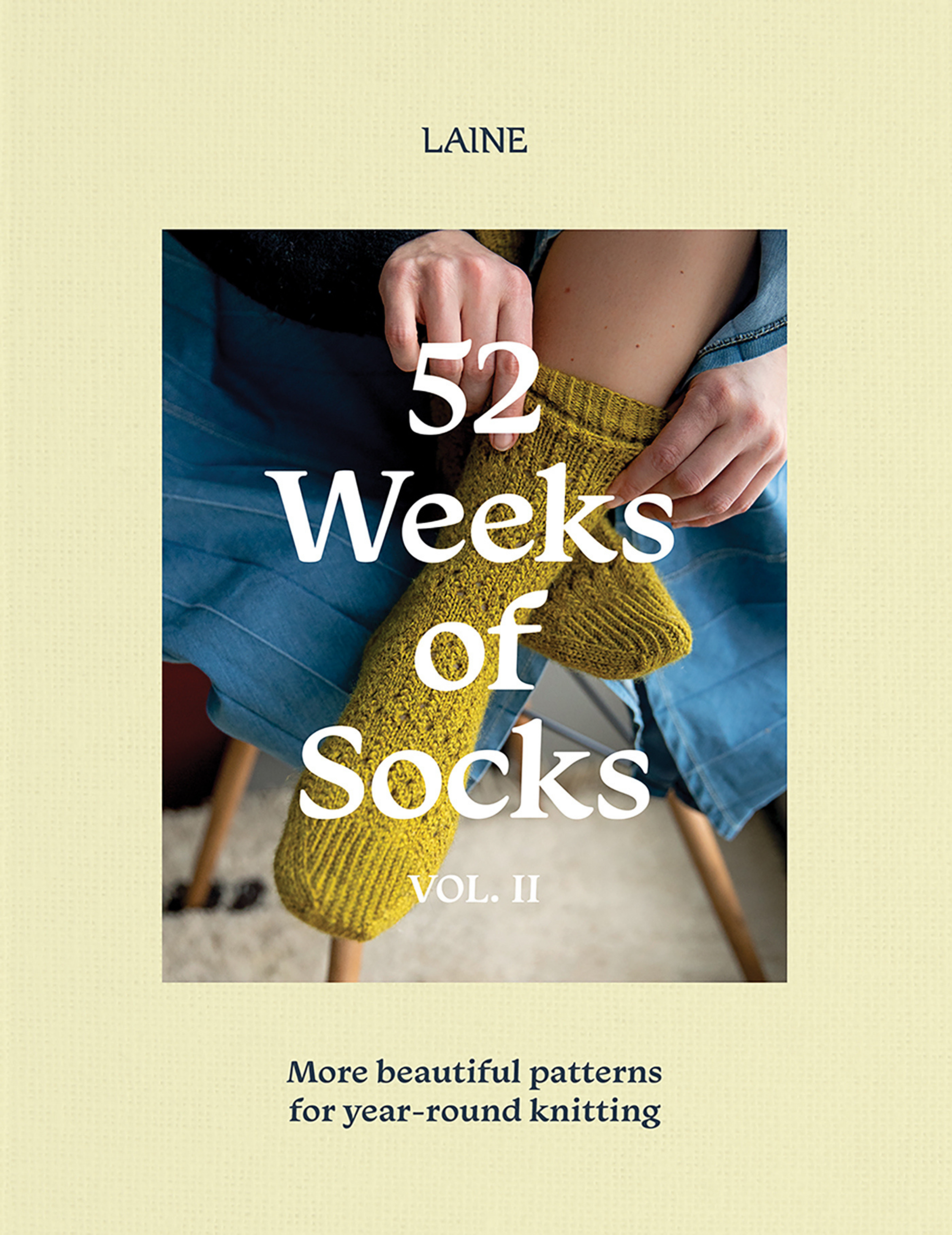 Book cover for '52 Weeks of Socks Vol. II' featuring a person wearing yellow knitted socks, set against a pastel yellow background.