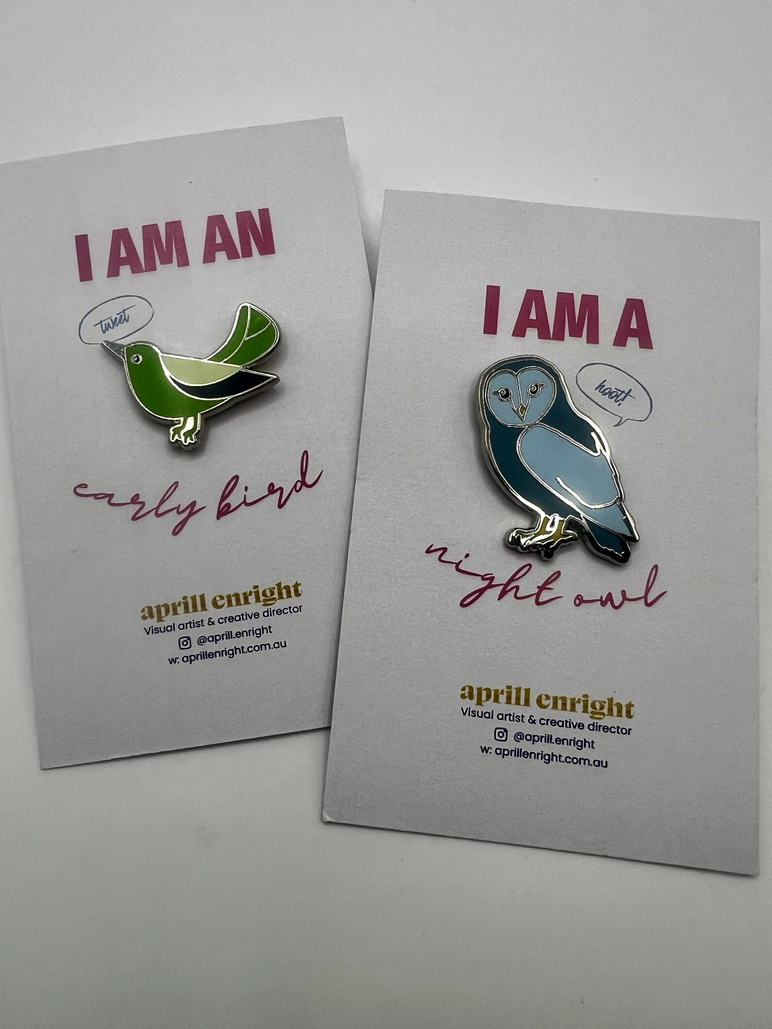Green early-bird and blue night-owl enamel pins on their backing cards, sold as a set