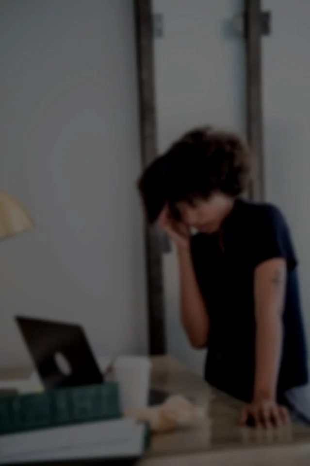 Person feeling overwhelmed at a desk, representing stress and mental fatigue