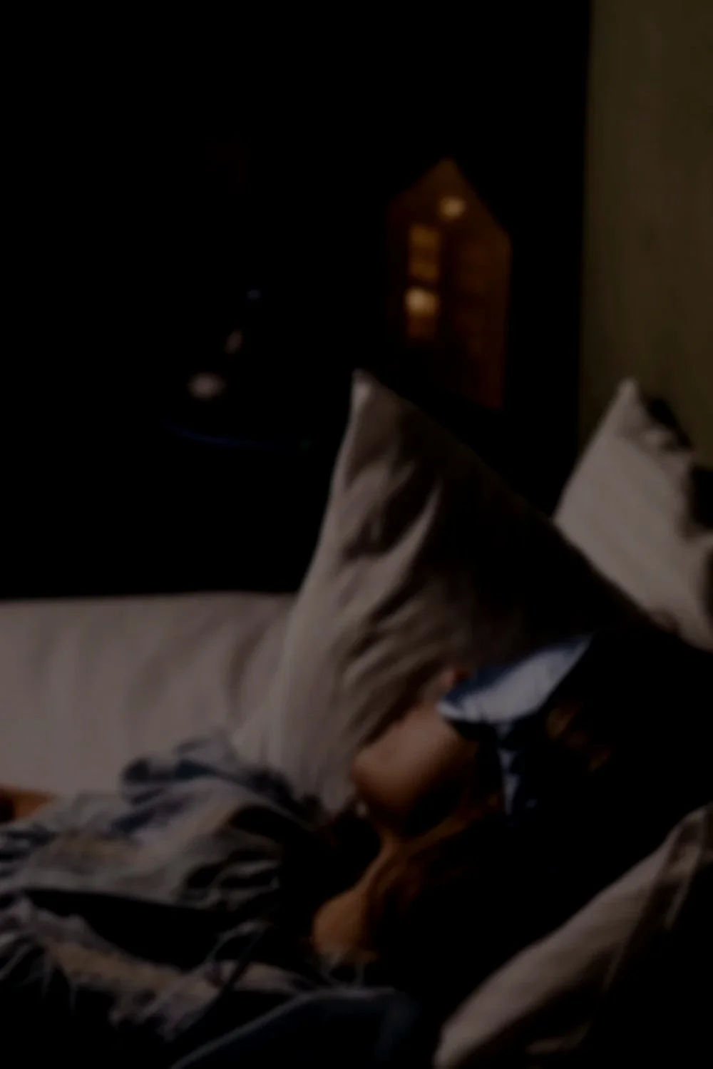Person resting in bed, representing sleep and restorative rest