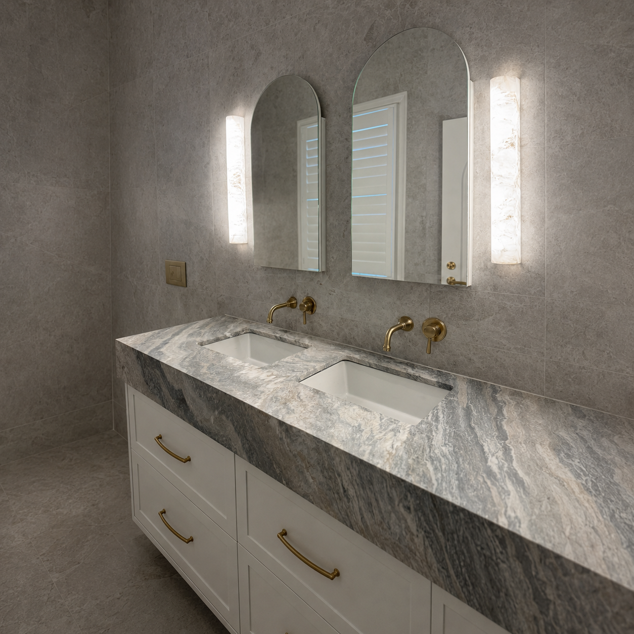 Modern bathroom with dual sinks, marble countertop, two mirrors, and mounted lights.
