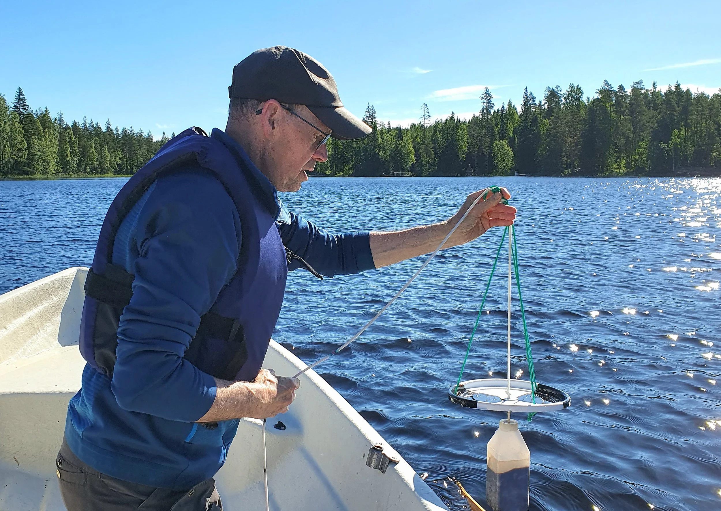 Yhdistyksen puheenjohtaja tekemässä näkösyvyystestiä soutuveneessä Ilmajärven pohjoispuolella.