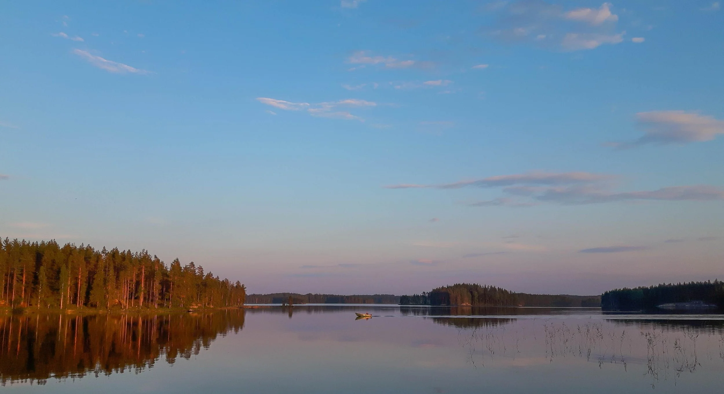 Vene järvellä auringonlaskun aikaan