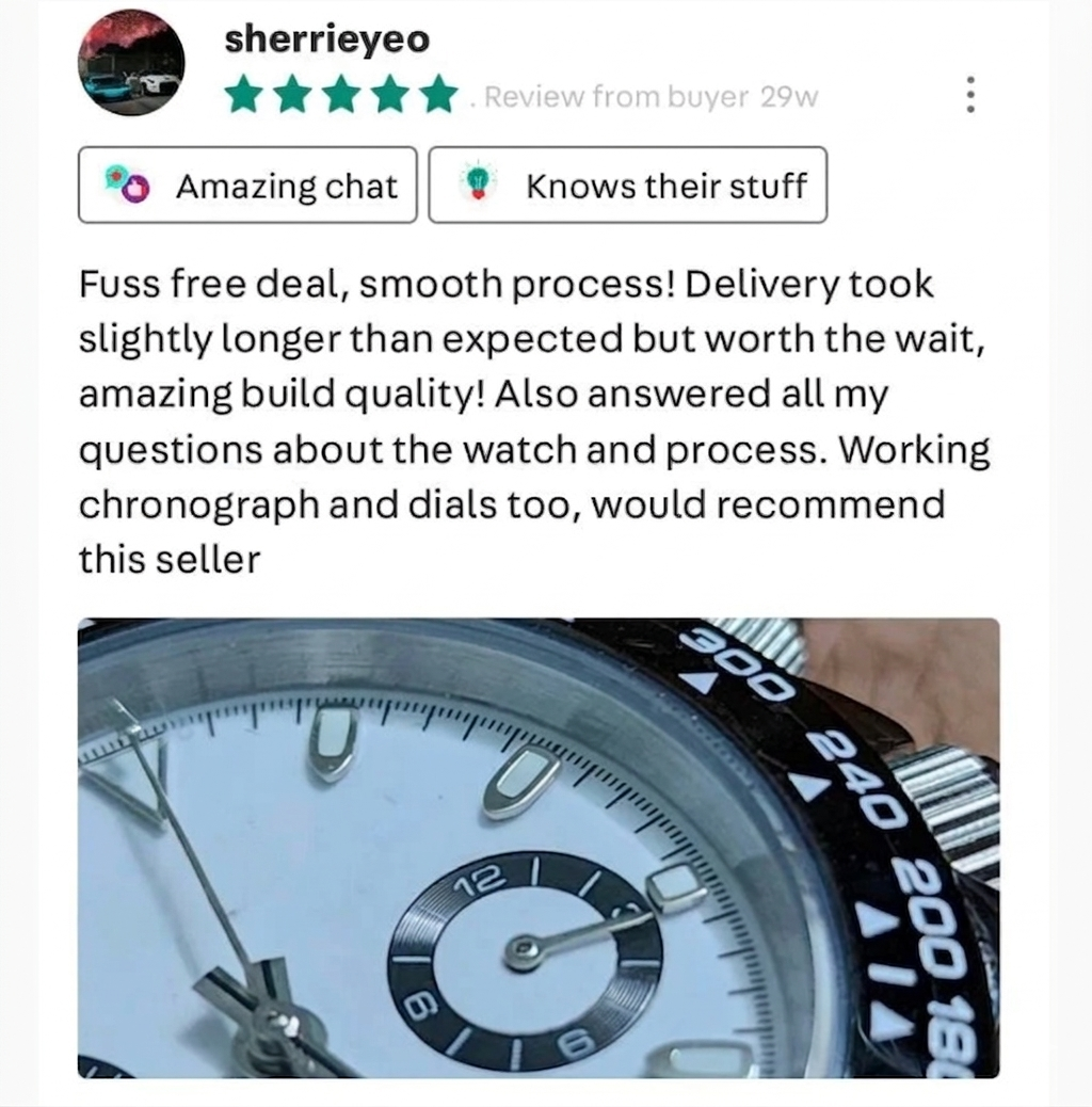 Close-up view of a luxury watch with a white face and black bezel, showing the watch's details and dials.