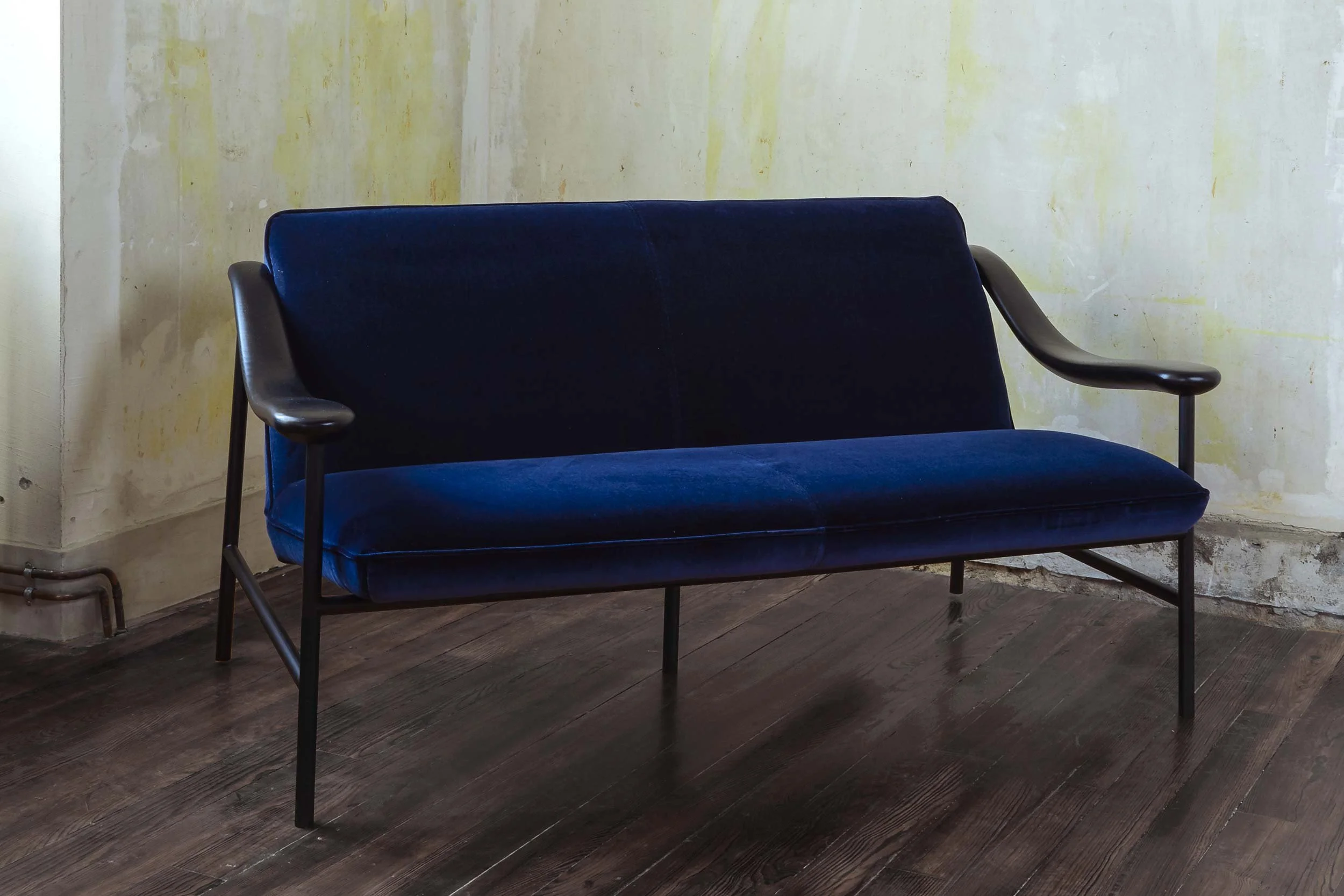 Sofa with a black stained oak armrest