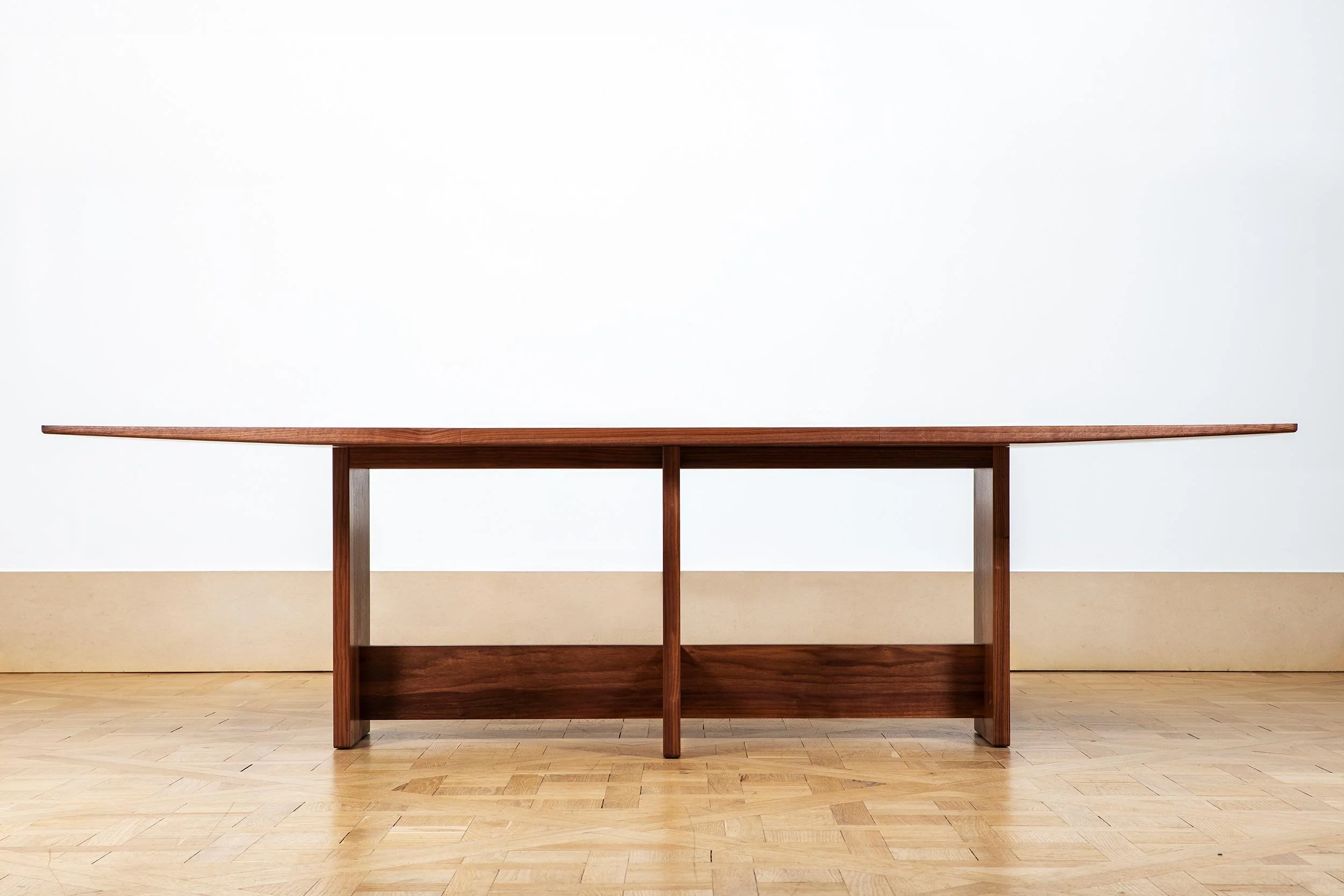 Floating table top on a solid architectural walnut structure