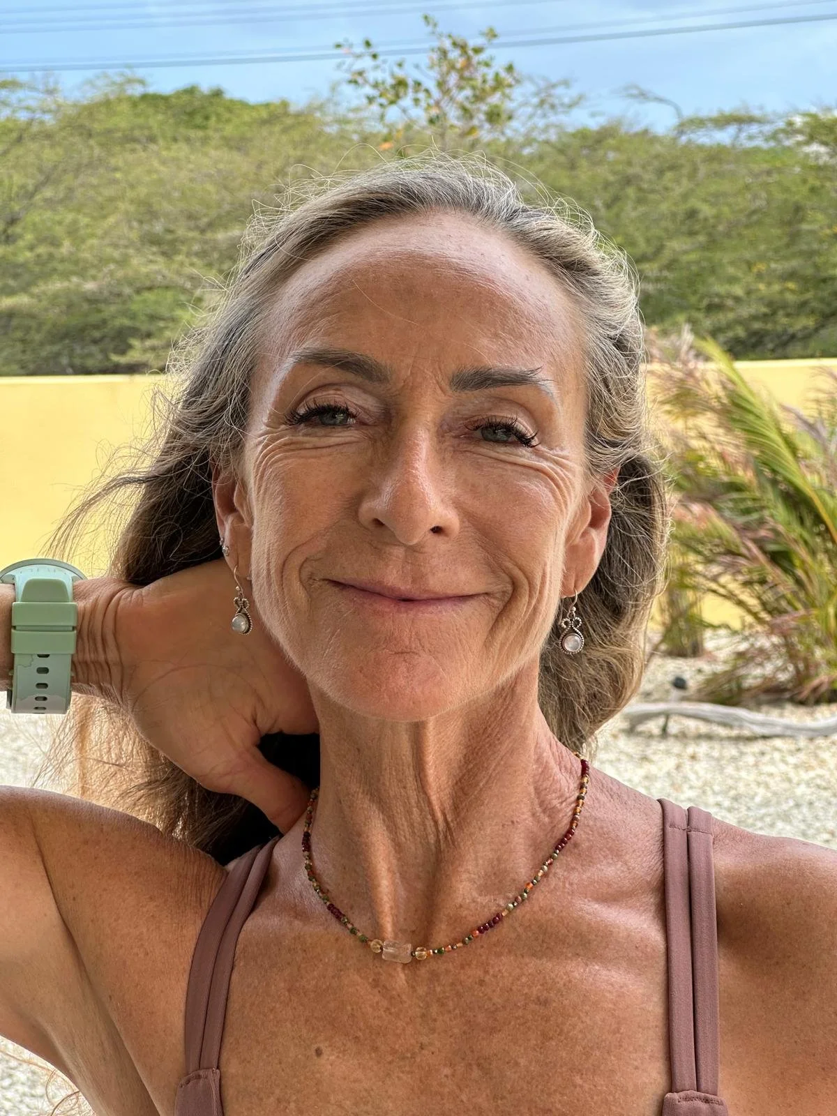 A Review of a woman wearing a beaded necklace.