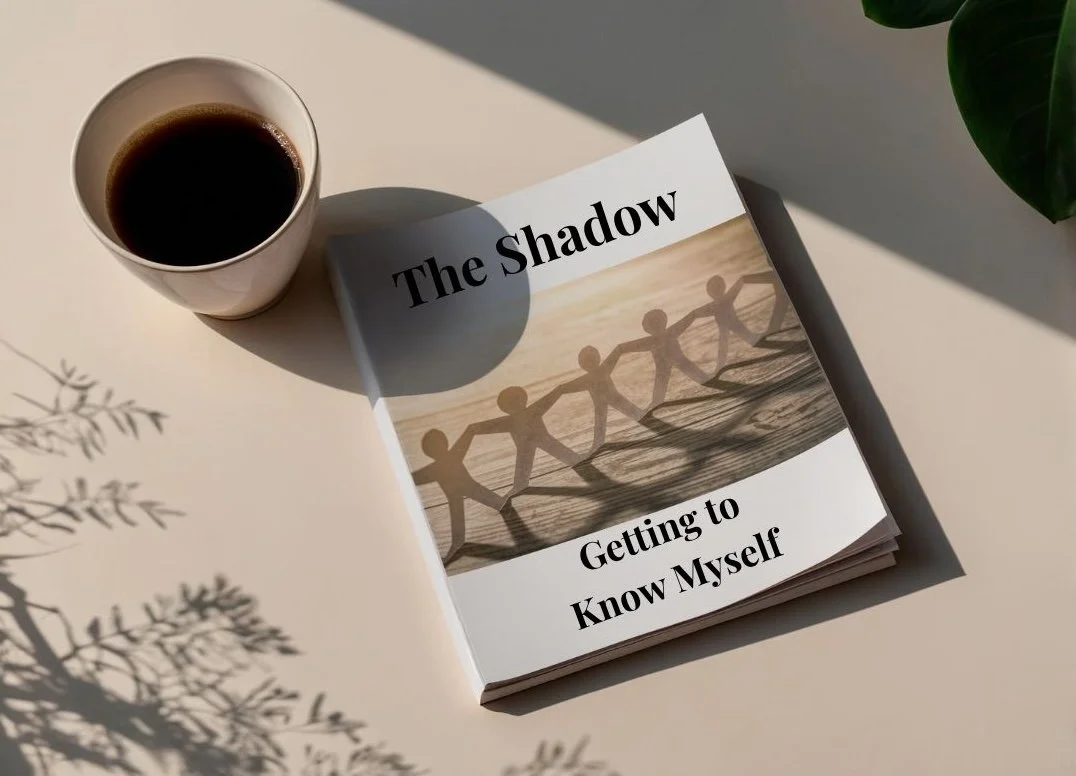 A cup of black coffee and a book titled "The Shadow: Getting to Know Myself" on a white surface with shadows from a plant and a green leafy plant in the background.