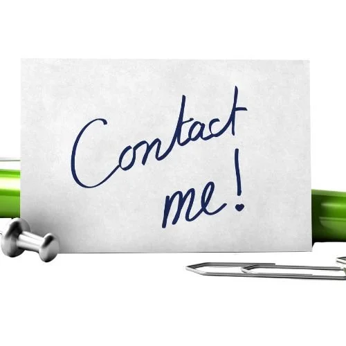 A handwritten note saying 'Contact me!' with a pen and green pens on a white surface.