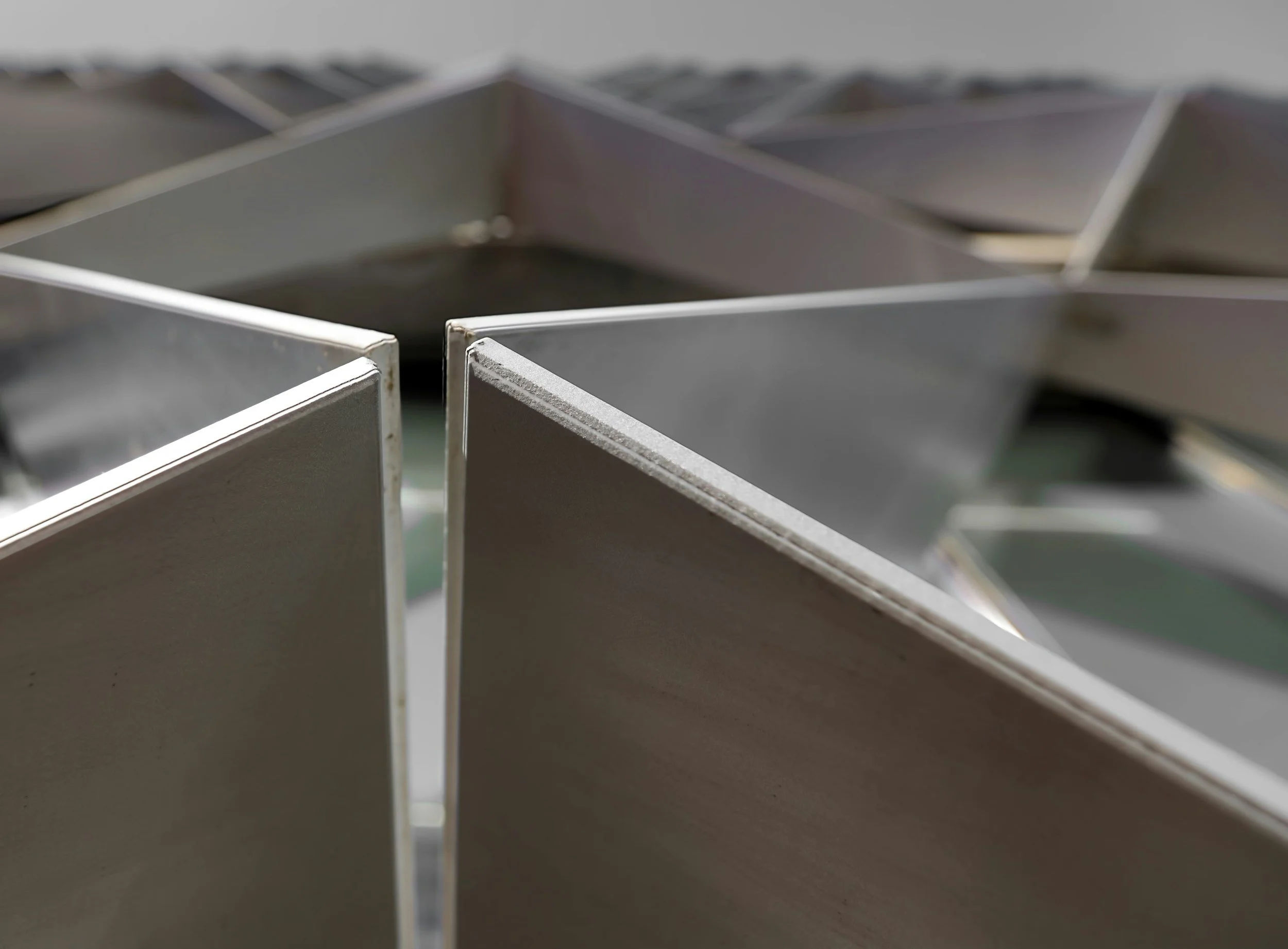Close-up of metal baking molds or pans arranged in rows.