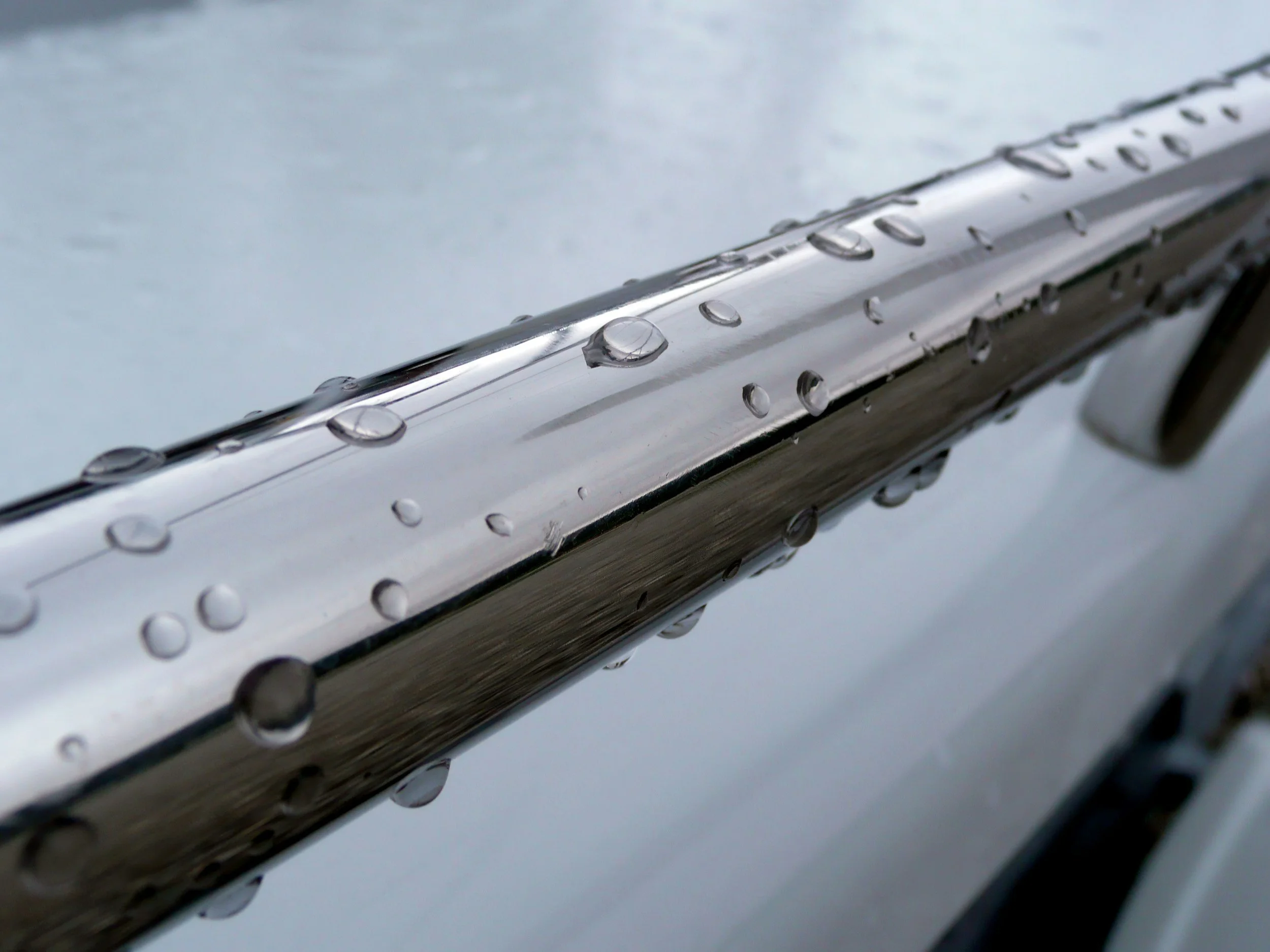 Close-up of a metal surface with water droplets on it.