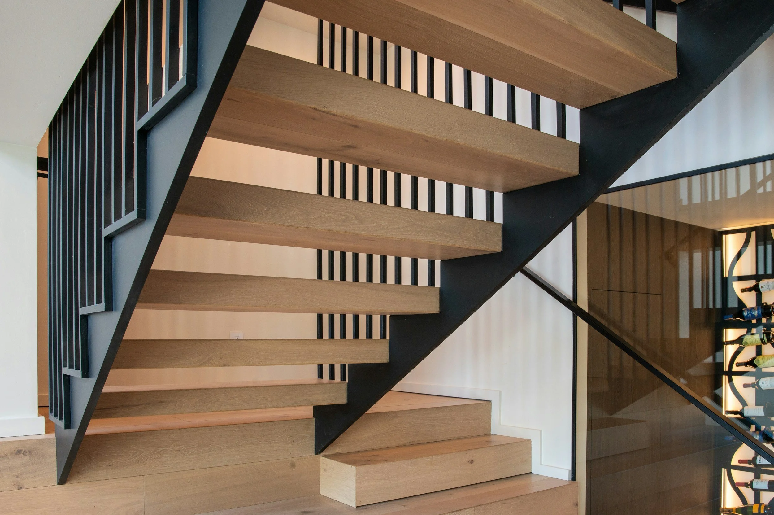 Wooden staircase with black steel railing by nottingham steel fabricator Gemfabs