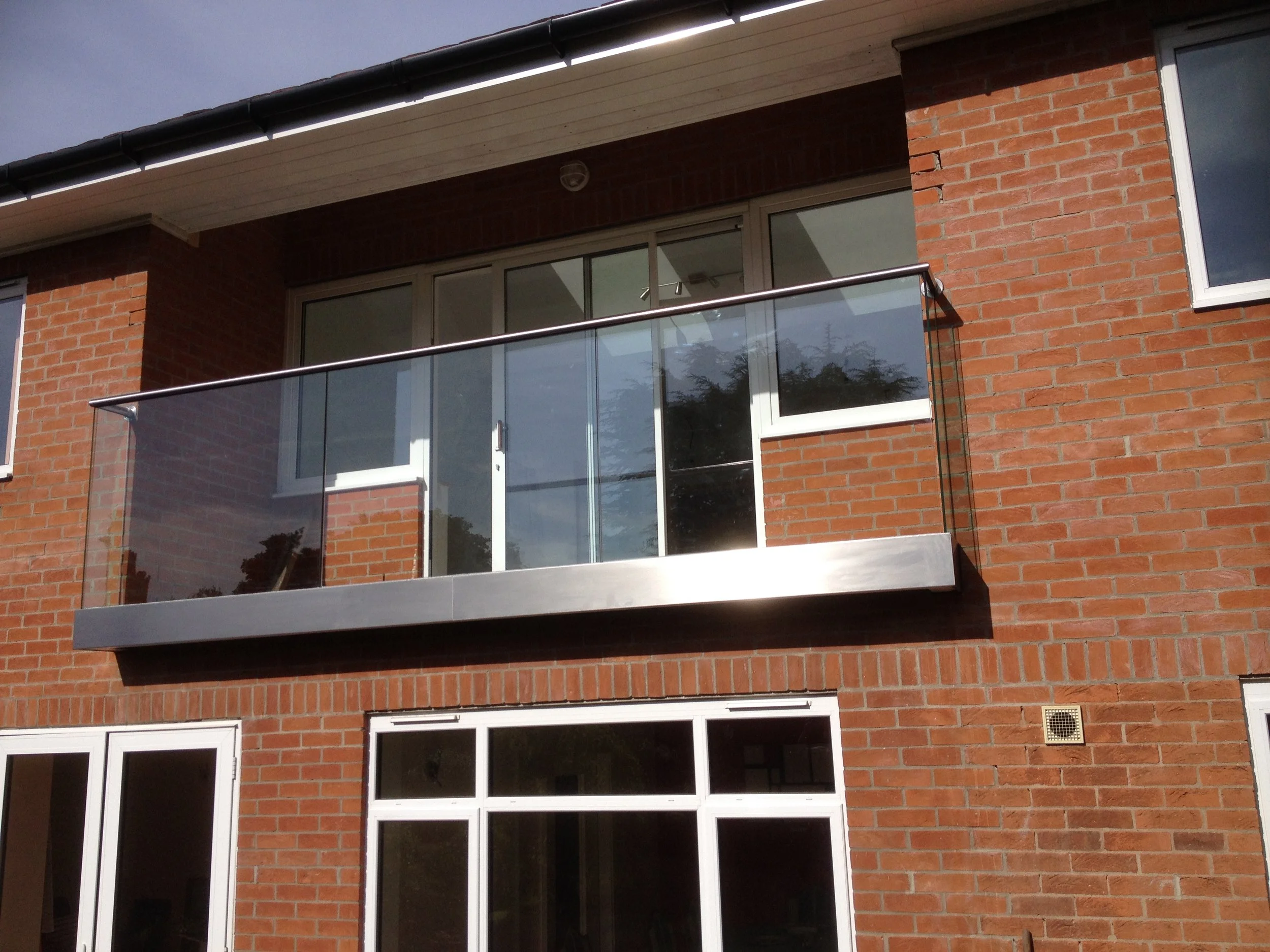 Stainless steel juliet balcony balustrade with glass panels by Gemfabs