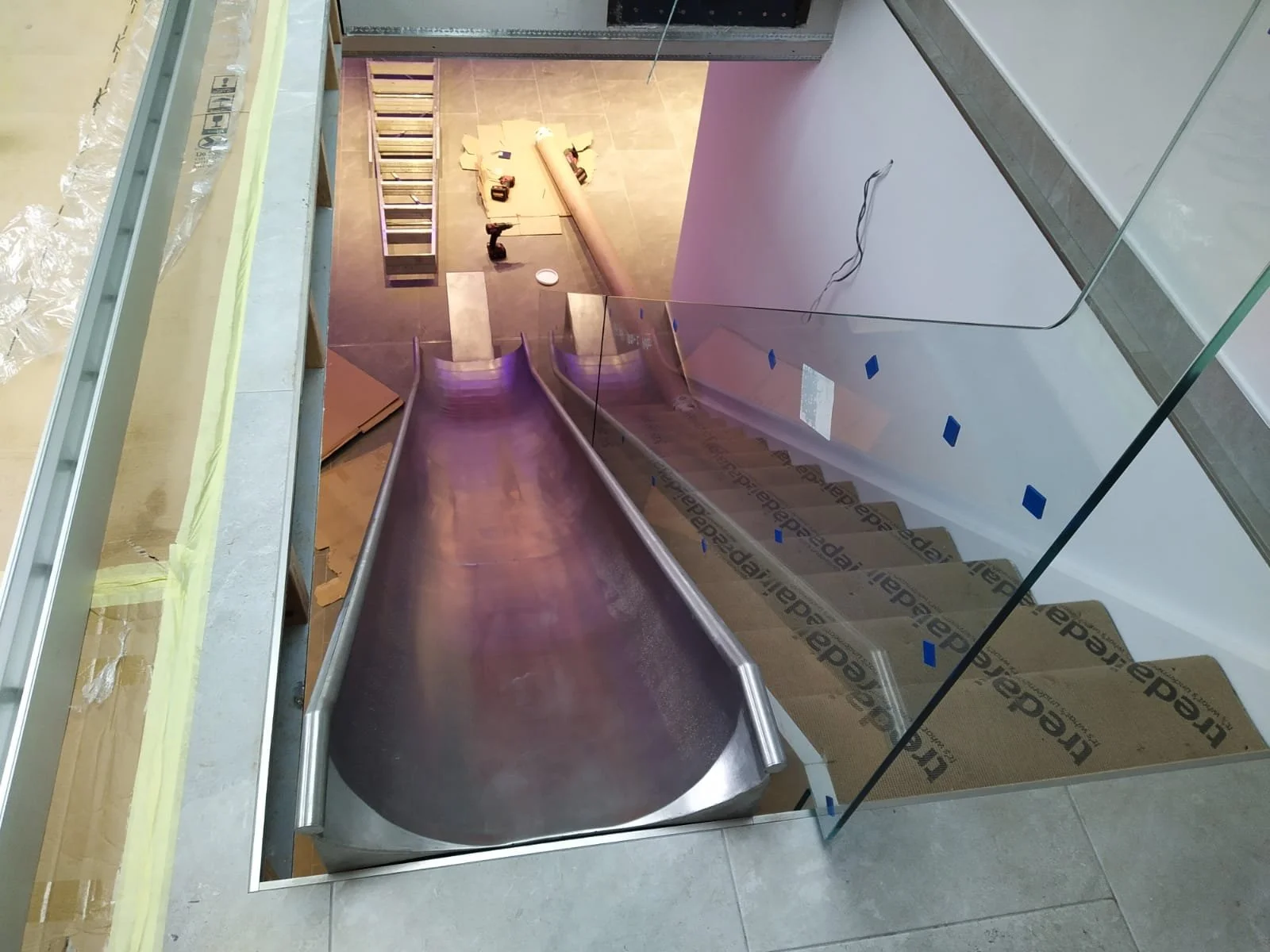 Industrial stainless steel slide with a glass railing staircase fabricated by Gemfabs Nottingham