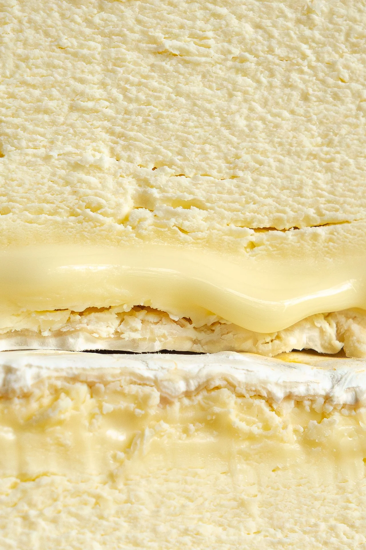 Gros plan d'une tranche de fromage Chaource AOP, montrant sa texture fine et crémeuse.
