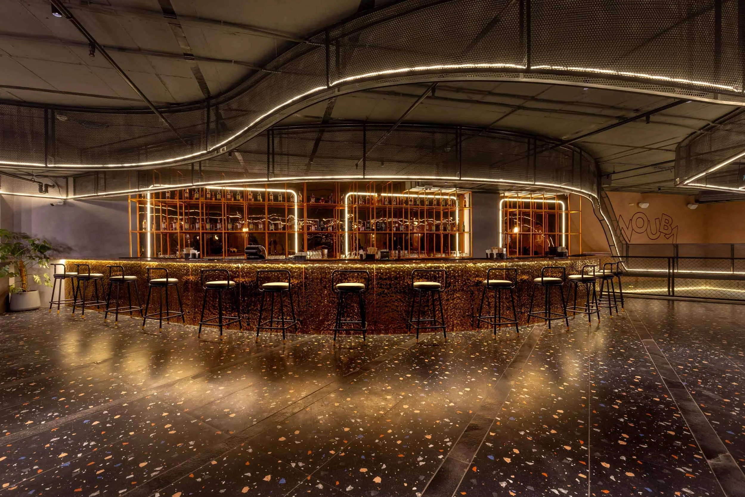 Commercial interior photography showcasing a luxury nightlife venue, highlighting custom central bar design, dramatic ambient lighting, and modern hospitality architecture