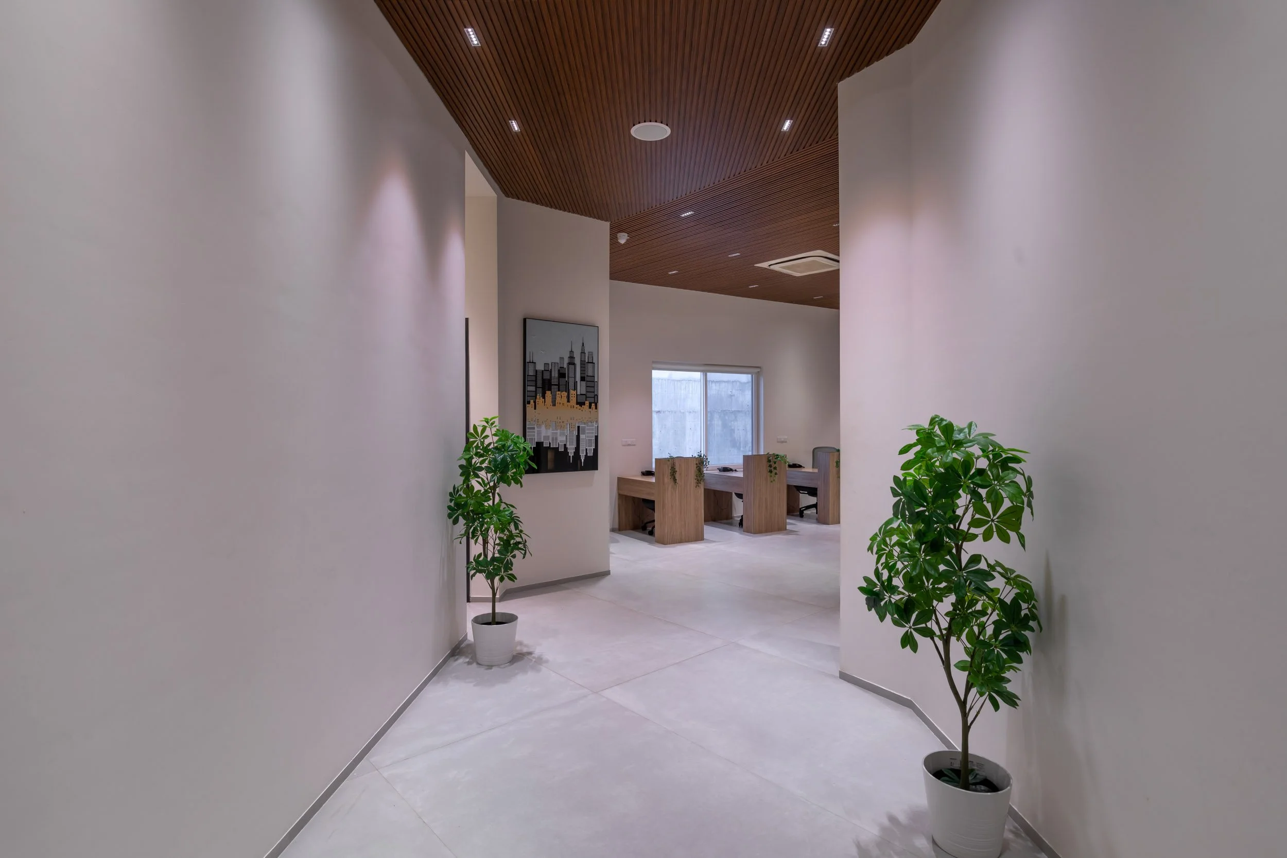 Interior commercial architecture photography showcasing a modern office hallway with polished floors, architectural wood ceiling accents, and biophilic design elements