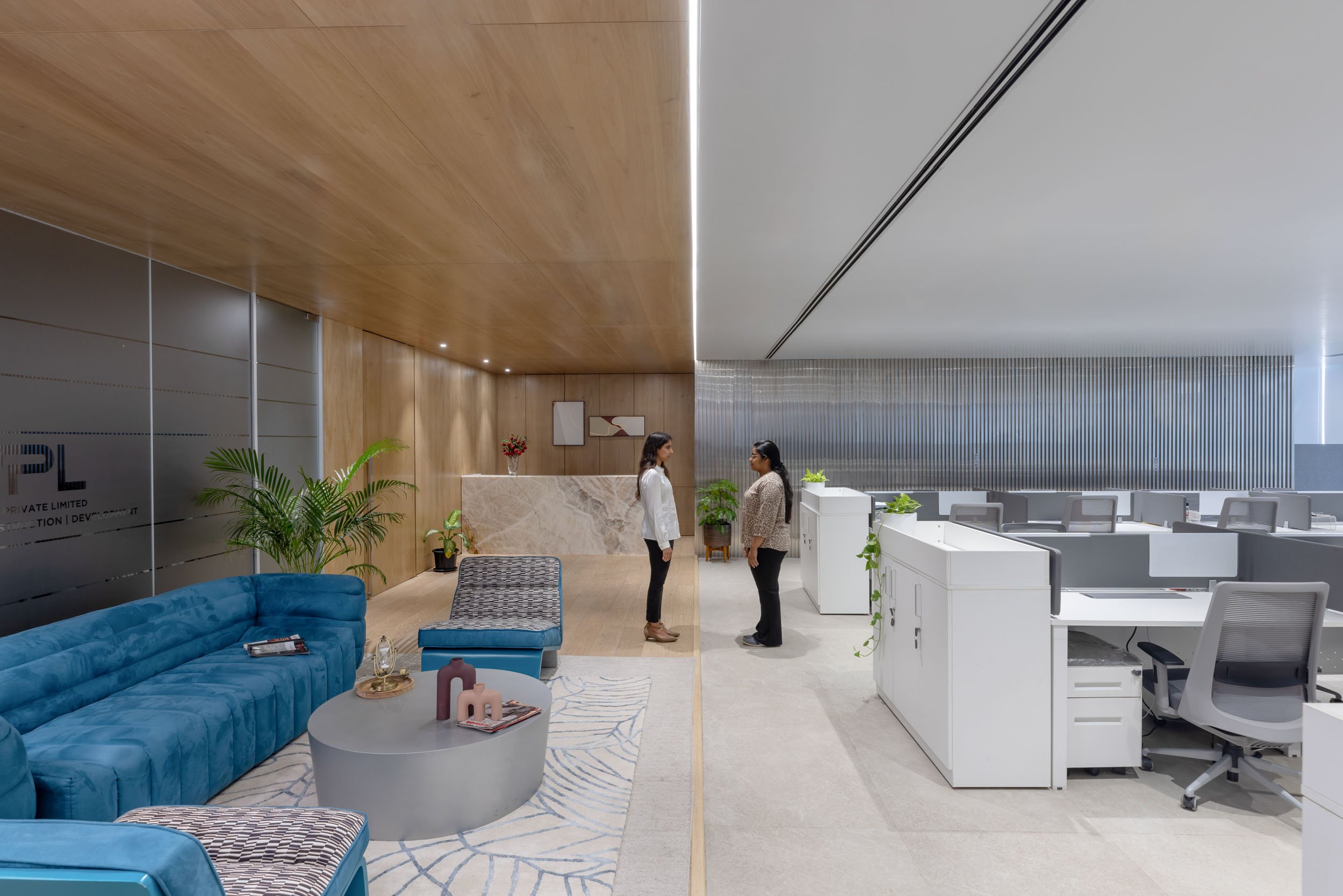 Commercial interior photography highlighting versatile office design, contrasting an inviting corporate reception lounge with a sleek, productive open-plan workspac
