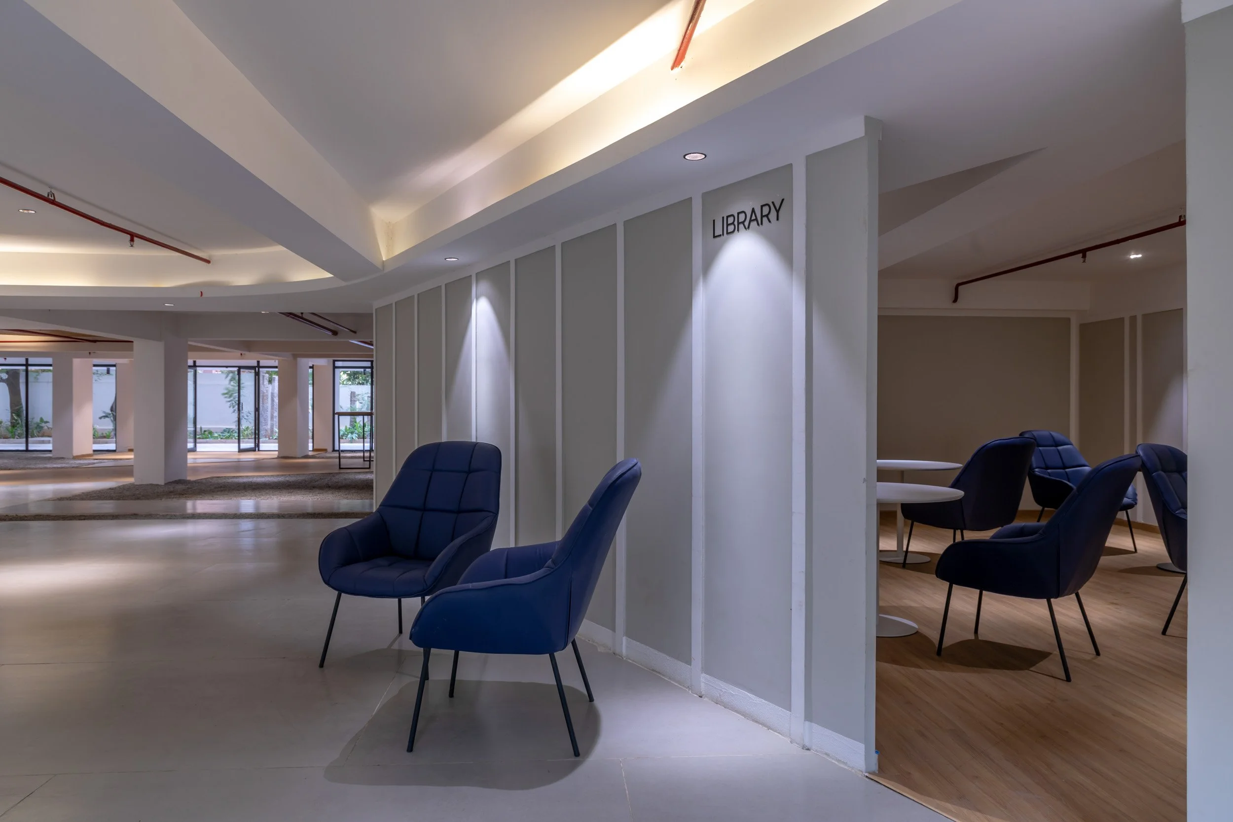 nterior architectural photography showcasing a modern commercial lobby or lounge, highlighting custom wall textures, integrated lighting design, and contemporary furnishing