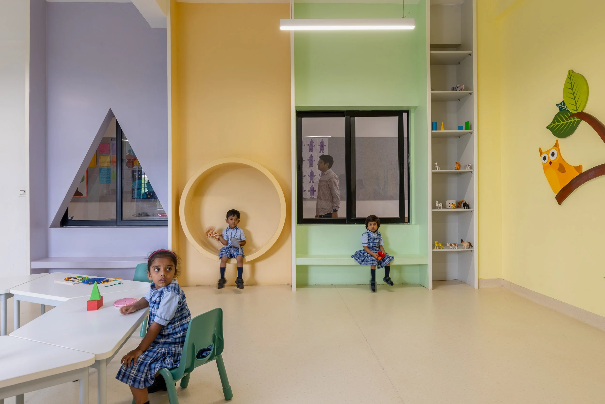 Interior school photography of students in a vibrant, modern early learning play area featuring colorful architectural details