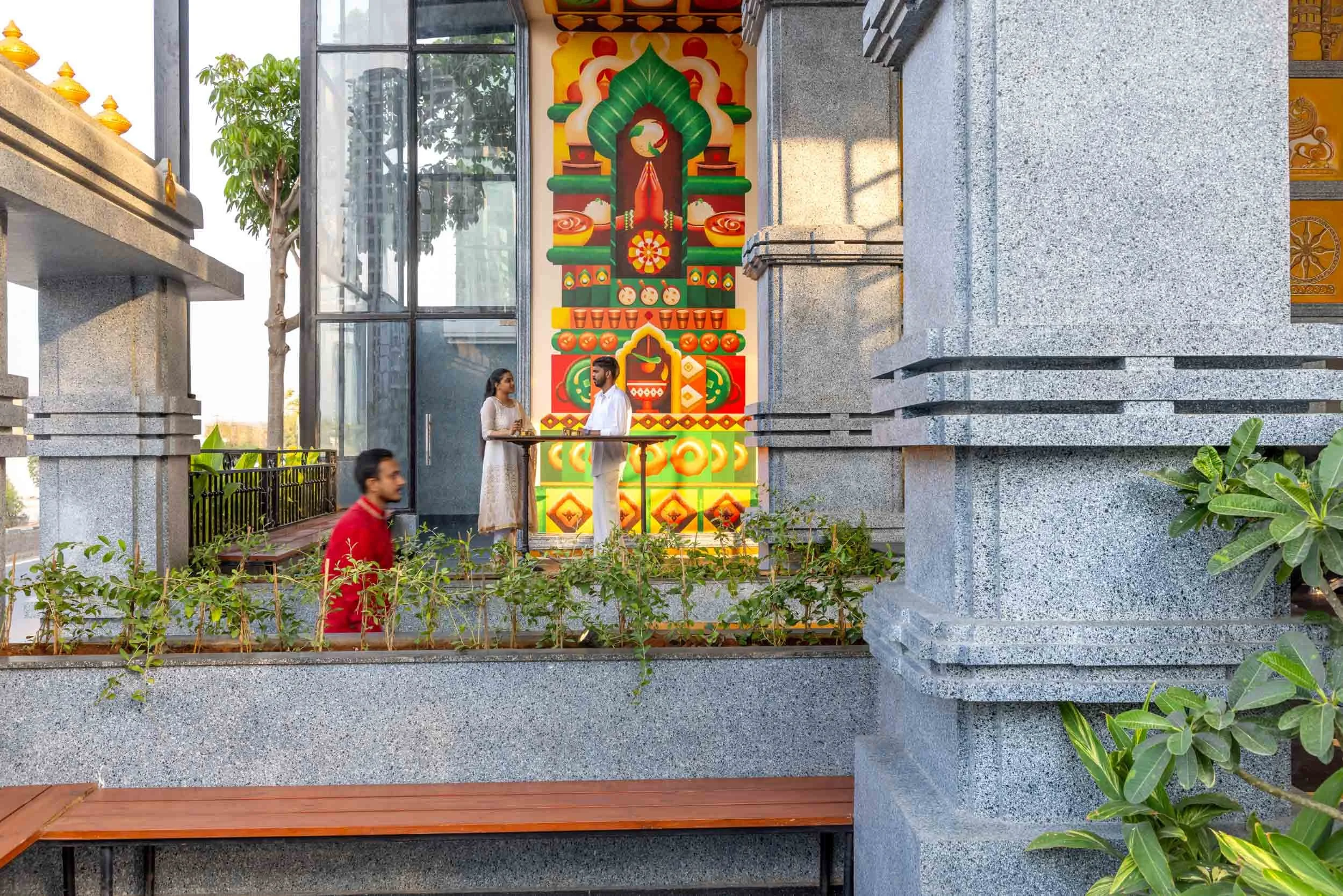 Commercial architectural photography showcasing a restaurant courtyard exterior, highlighting stone column design, landscape integration, and custom outdoor mural art