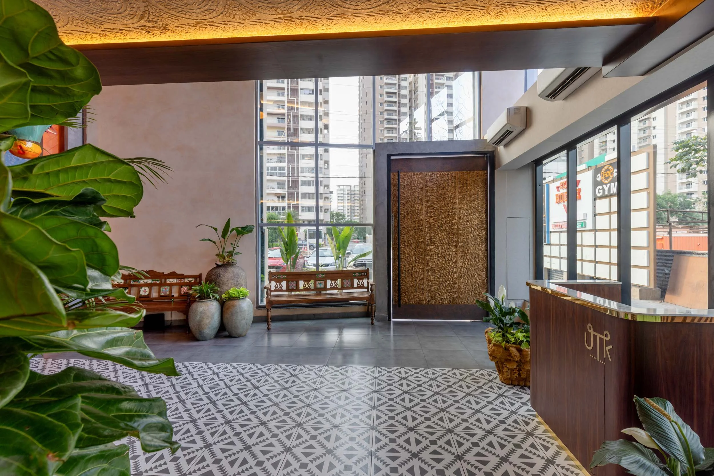 Commercial interior photography showcasing a modern restaurant entrance, highlighting custom patterned tile floors, natural daylighting, and transitional hospitality spaces