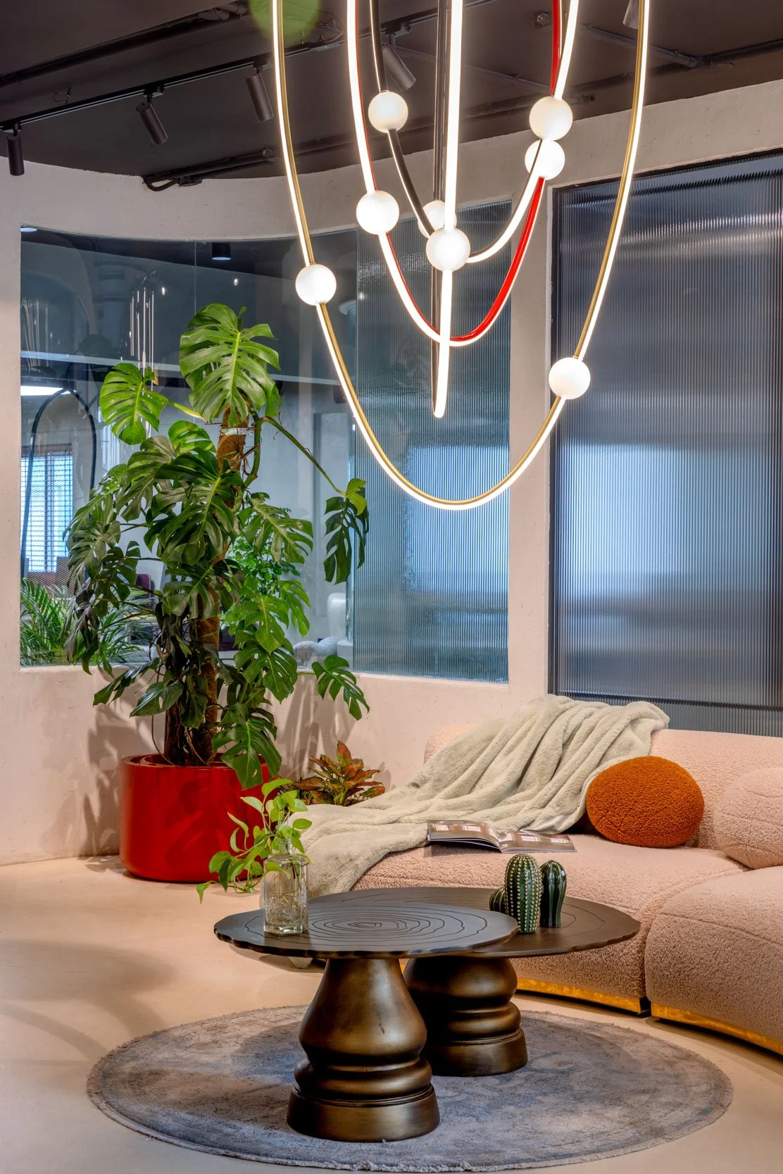 Commercial interior photography of a modern corporate lounge space, highlighting unique statement lighting, comfortable seating arrangements, and interior styling